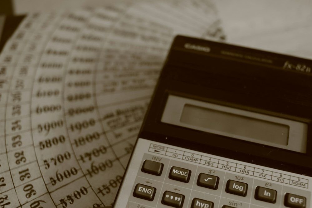 A calculator on handwritten accounting ledger sheets