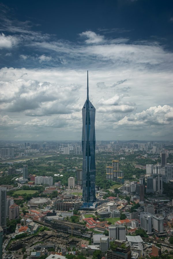 Merdeka 118 tower and surrounding Kuala Lumpur buildings under clouds