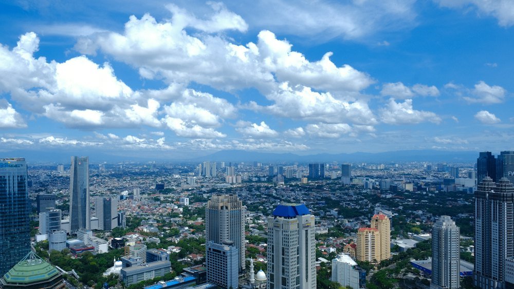 Jakarta skyline under a bright blue cloudy sky