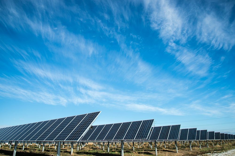 A ground-mounted solar power array beneath a blue sky