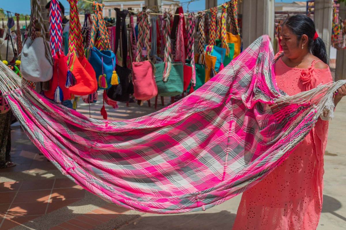 A woman displays handwoven crafts at a market stall